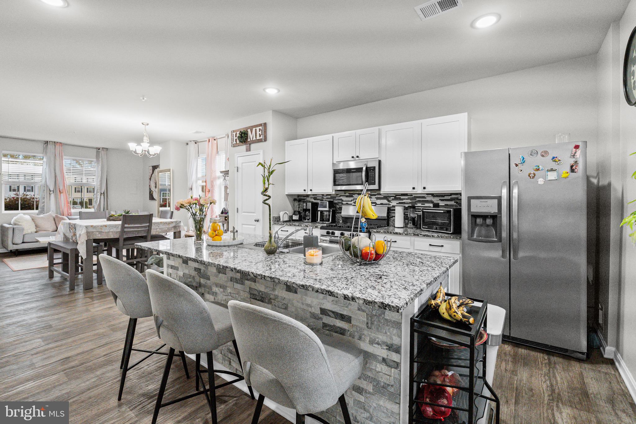 1901 Graymount Way Edgewood, MD 21040 - Photo 4 of 24 a kitchen with stainless steel appliances granite countertop a dining table chairs refrigerator and microwave