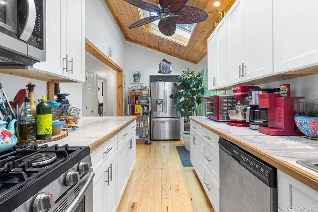 a large kitchen with stainless steel appliances granite countertop a lot of counter space and a sink