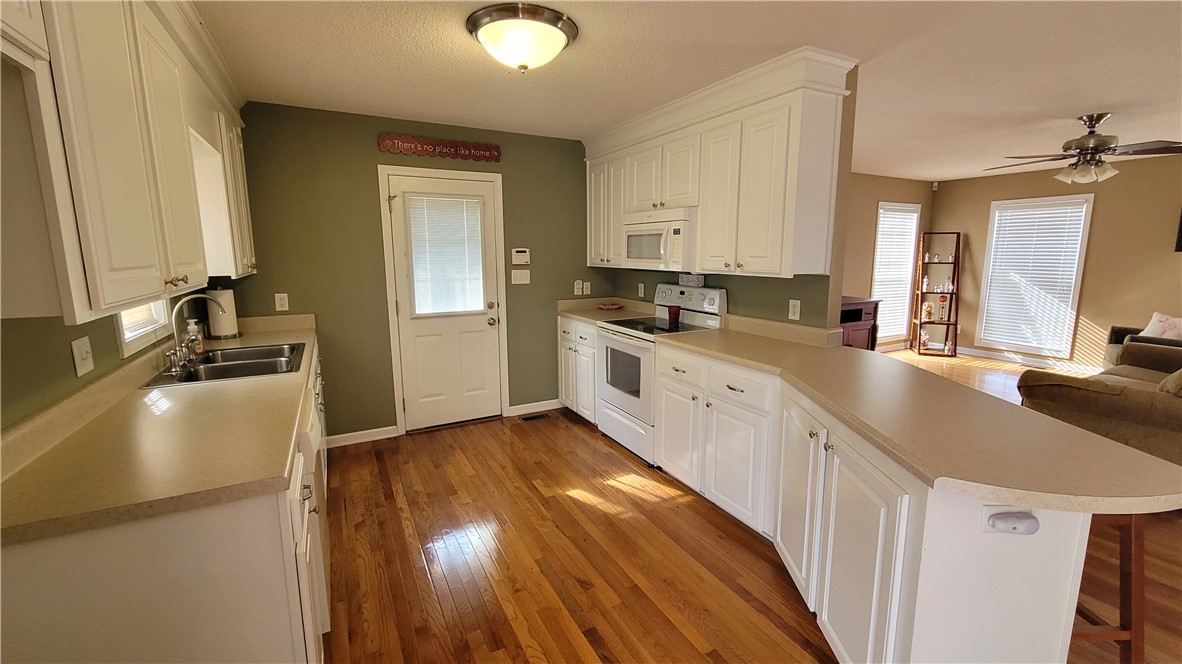 325 McAdams School Road Honea Path, SC 29654 - Photo 6 of 22 A well-appointed kitchen features ample counter space and natural wood flooring, seamlessly connecting to a bright living area.