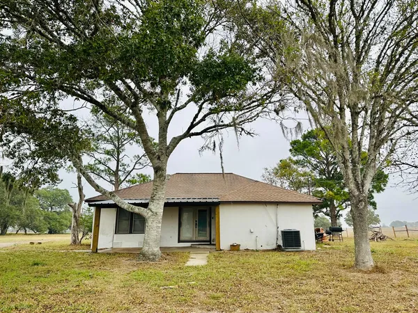 a front view of house with yard and trees