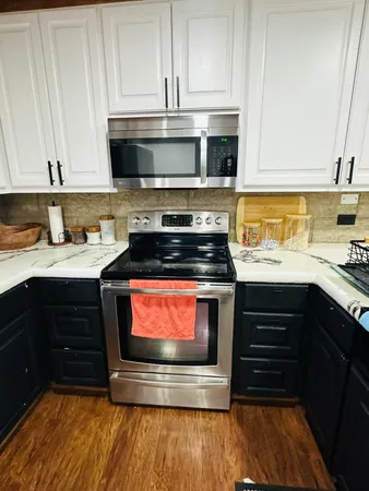 a kitchen with stainless steel appliances a stove a sink and a microwave