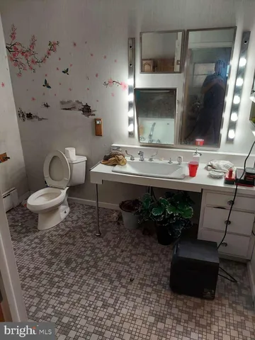 a bathroom with a sink toilet and mirror