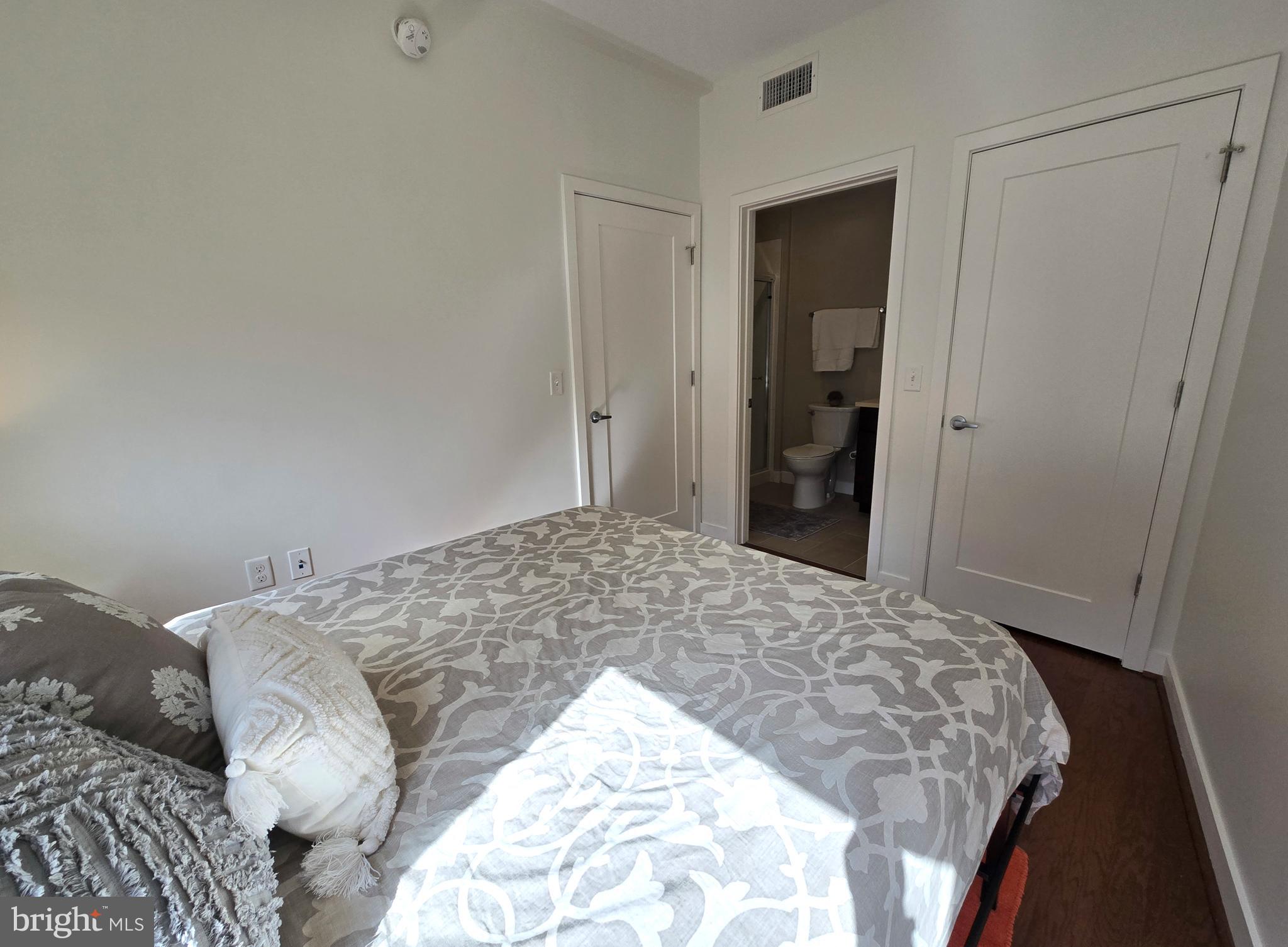 1320 Fenwick Lane, Unit 508 Silver Spring, MD 20910 - Photo 16 of 47 a bedroom with a bed and a mirror