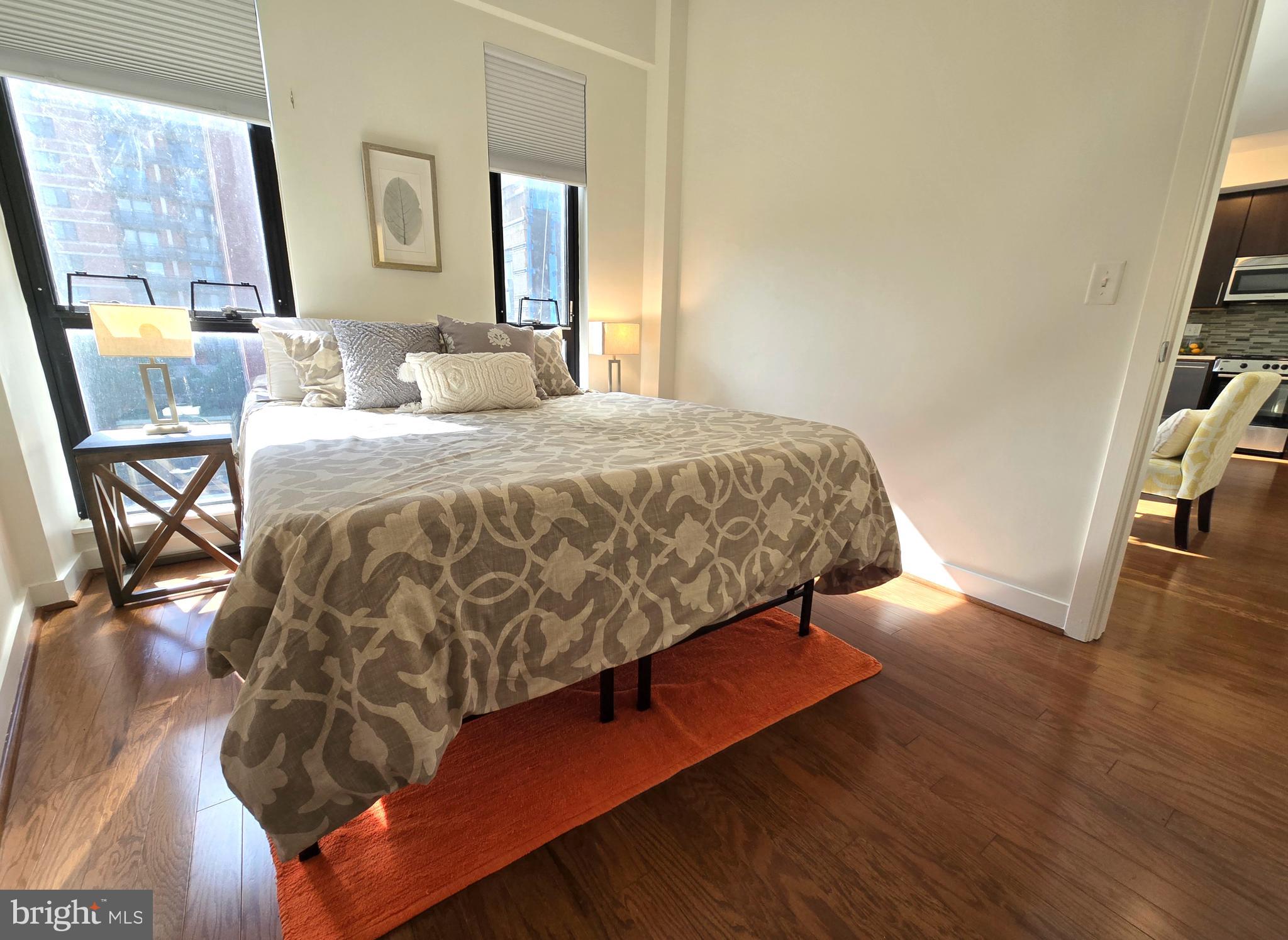 1320 Fenwick Lane, Unit 508 Silver Spring, MD 20910 - Photo 19 of 47 a bedroom with a bed and wooden floor