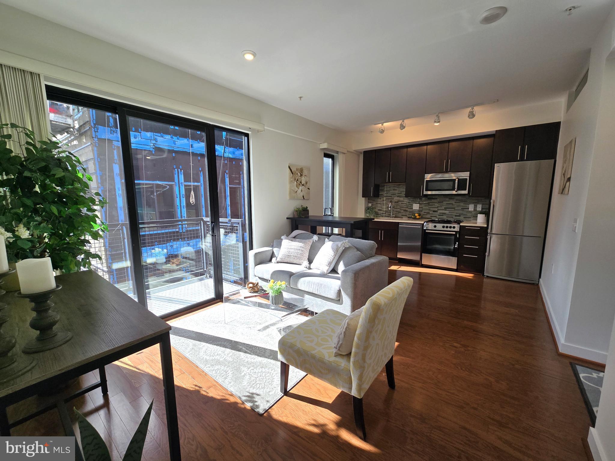 1320 Fenwick Lane, Unit 508 Silver Spring, MD 20910 - Photo 2 of 47 a living room with furniture a large window and a dining table