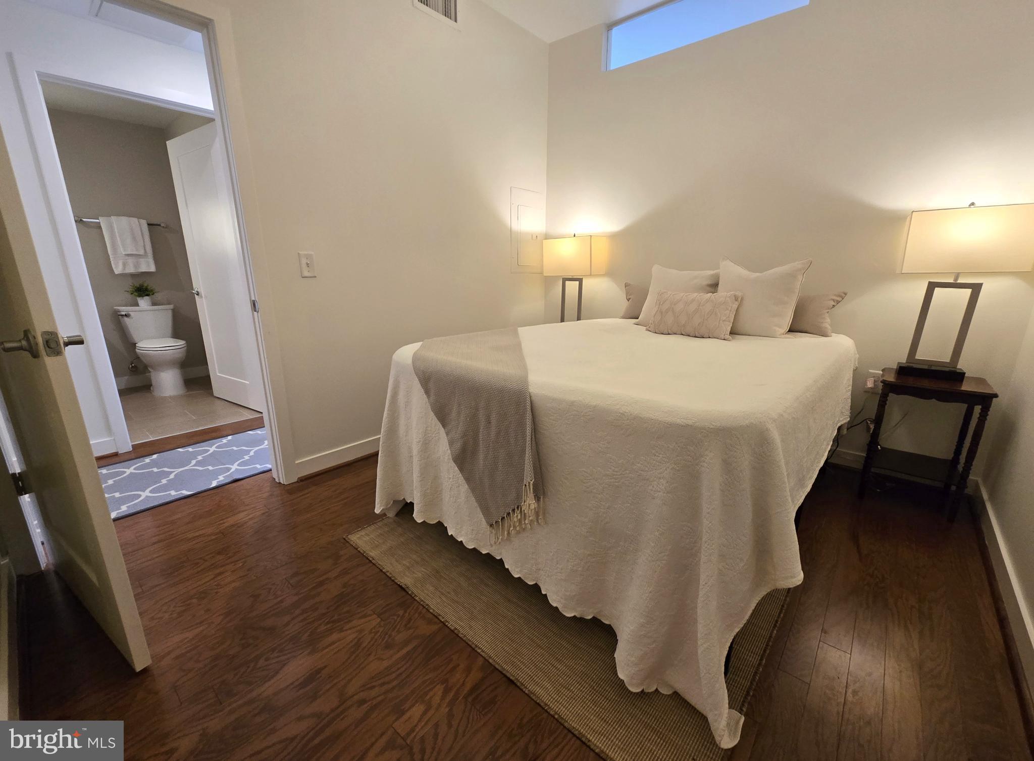 1320 Fenwick Lane, Unit 508 Silver Spring, MD 20910 - Photo 24 of 47 a bedroom with a bed and a mirror