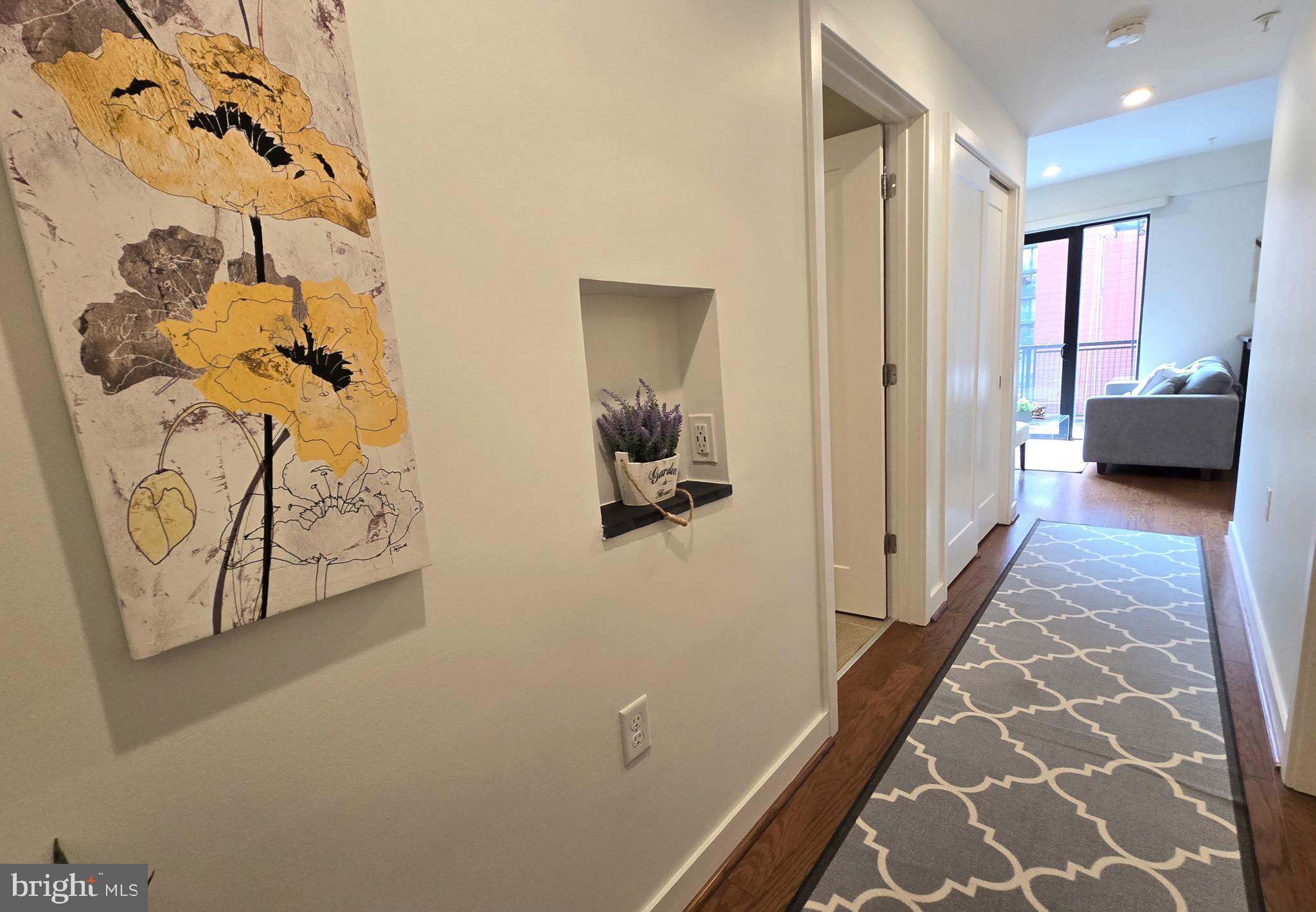 1320 Fenwick Lane, Unit 508 Silver Spring, MD 20910 - Photo 4 of 47 a view of a hallway with wooden floor and a potted plant