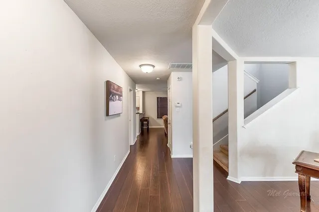 a view of a hallway with wooden floor and staircase