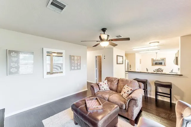 a living room with furniture and a wooden floor