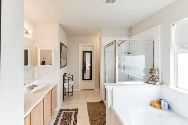 a bathroom with a tub sink and mirror
