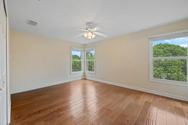 a view of room with window ceiling fan and hardwood floor