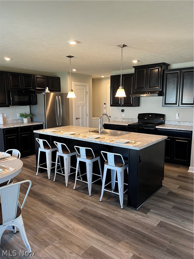 15012 Decourcey Rittman, OH 44270 - Photo 8 of 26 Kitchen with an island with sink, dark wood-type flooring, stove, and decorative light fixtures
