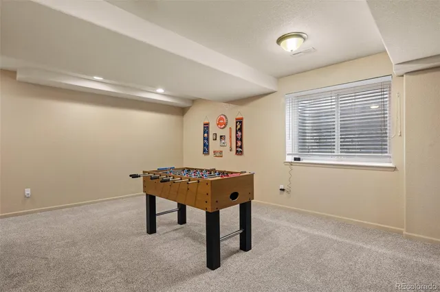 a bedroom with a bed a painting on the wall and a window