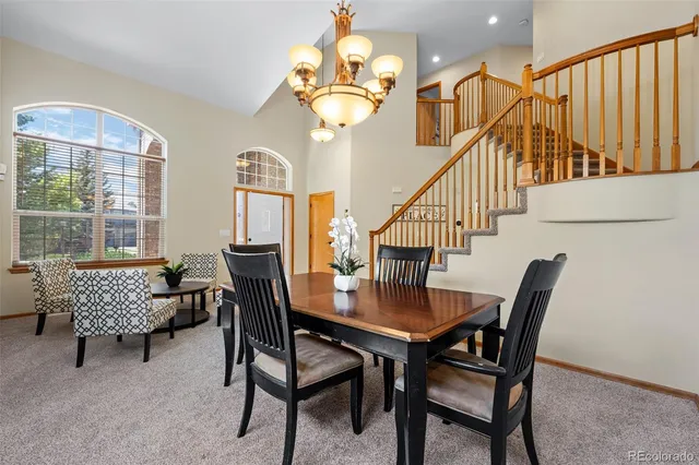 a dining room with furniture a chandelier and wooden floor