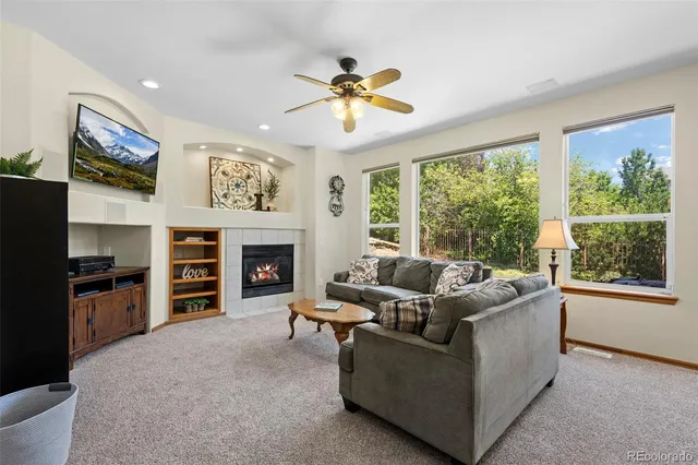 a living room with furniture a large window and a fireplace