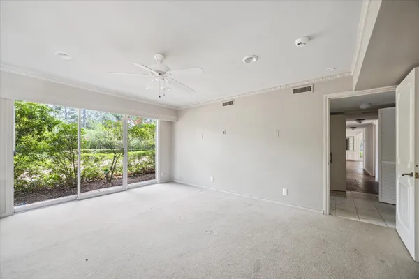 a large white bathroom with a granite countertop sink and a mirror