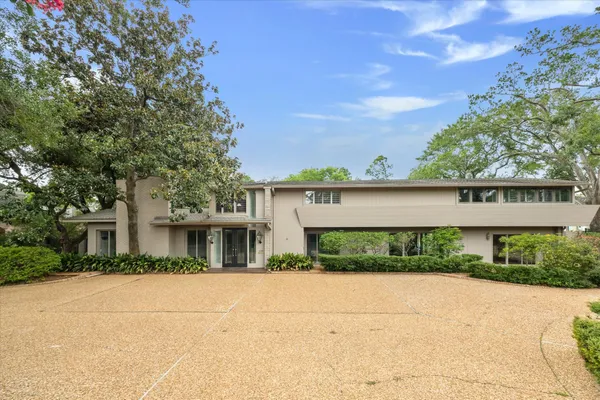 a front view of a house with a yard and potted plants