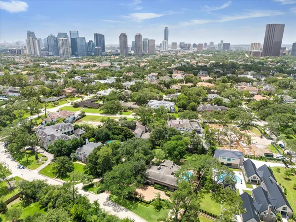 an aerial view of residential houses with outdoor space and trees