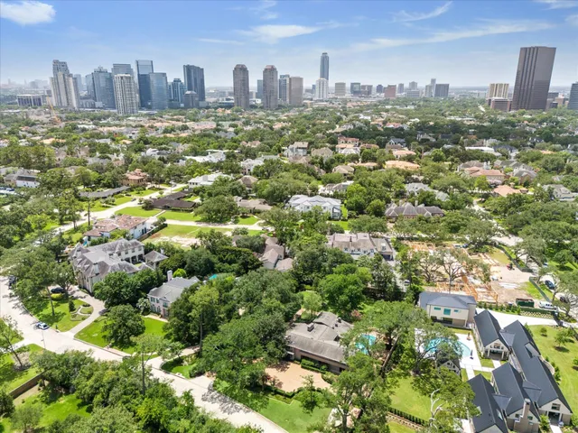 an aerial view of residential houses with outdoor space and trees