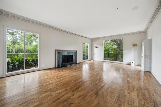 a view of empty room with wooden floor and fireplace