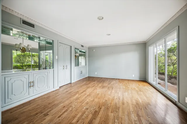 a view of a big room with wooden floor and windows