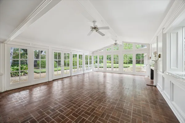 a view of empty room with wooden floor and fan