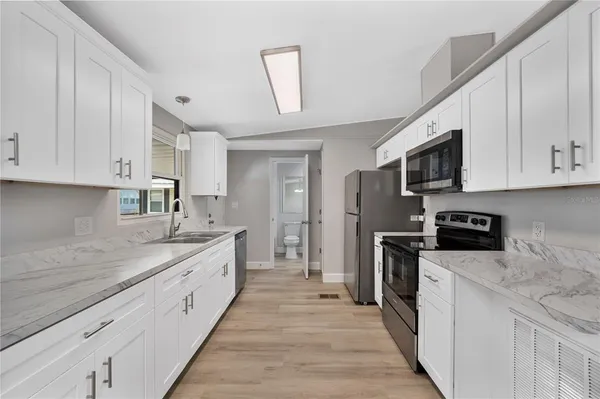 a kitchen with stainless steel appliances granite countertop a sink stove and refrigerator