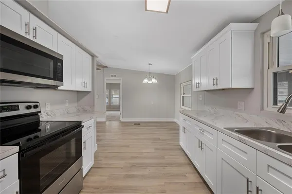 a kitchen with stainless steel appliances a stove microwave and sink
