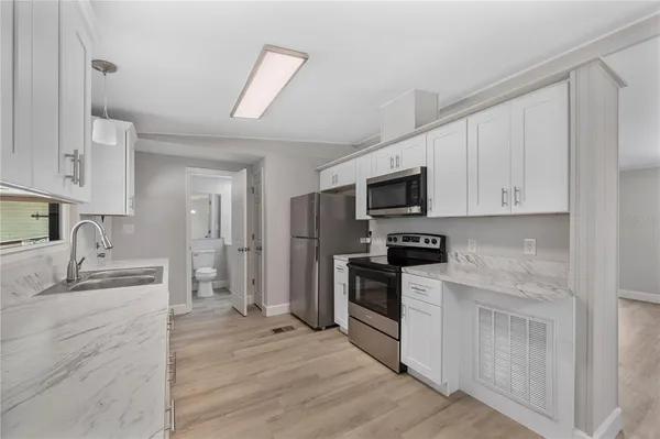 a kitchen with granite countertop a sink stainless steel appliances and cabinets