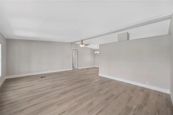 a view of an empty room with wooden floor