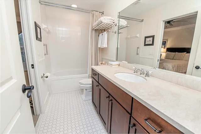 a bathroom with a double vanity sink toilet mirror and shower