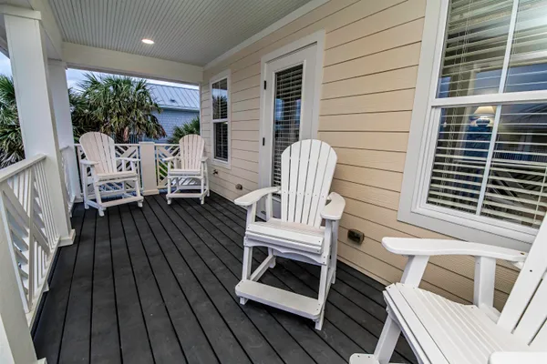 a balcony with wooden floor table and chairs