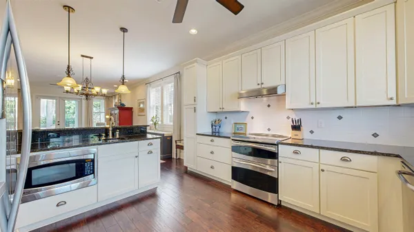 a kitchen with stove and wooden floor