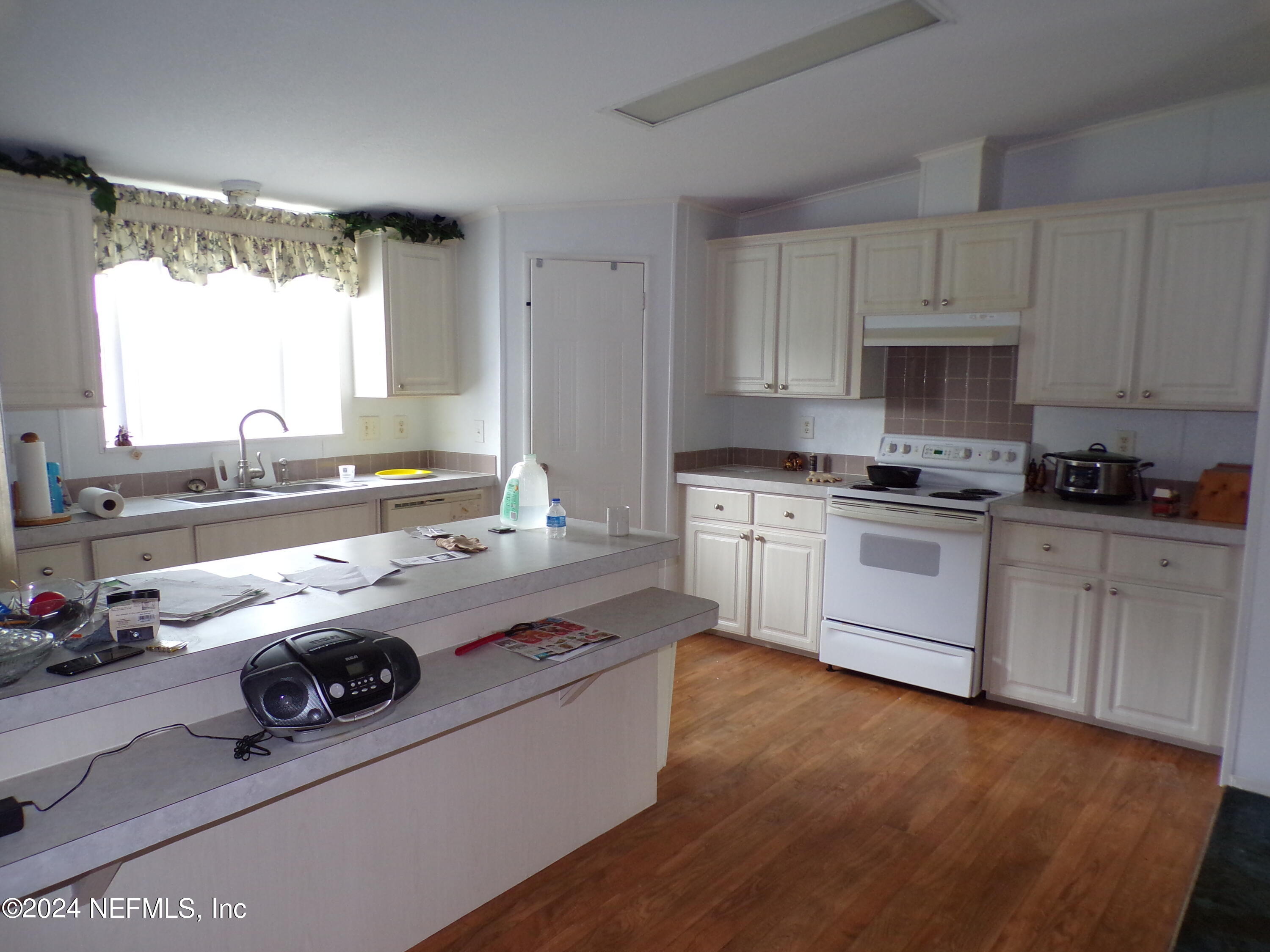 10642 East Bay Road Gibsonton, FL 33534 - Photo 12 of 32 a kitchen with kitchen island granite countertop a sink appliances and cabinets