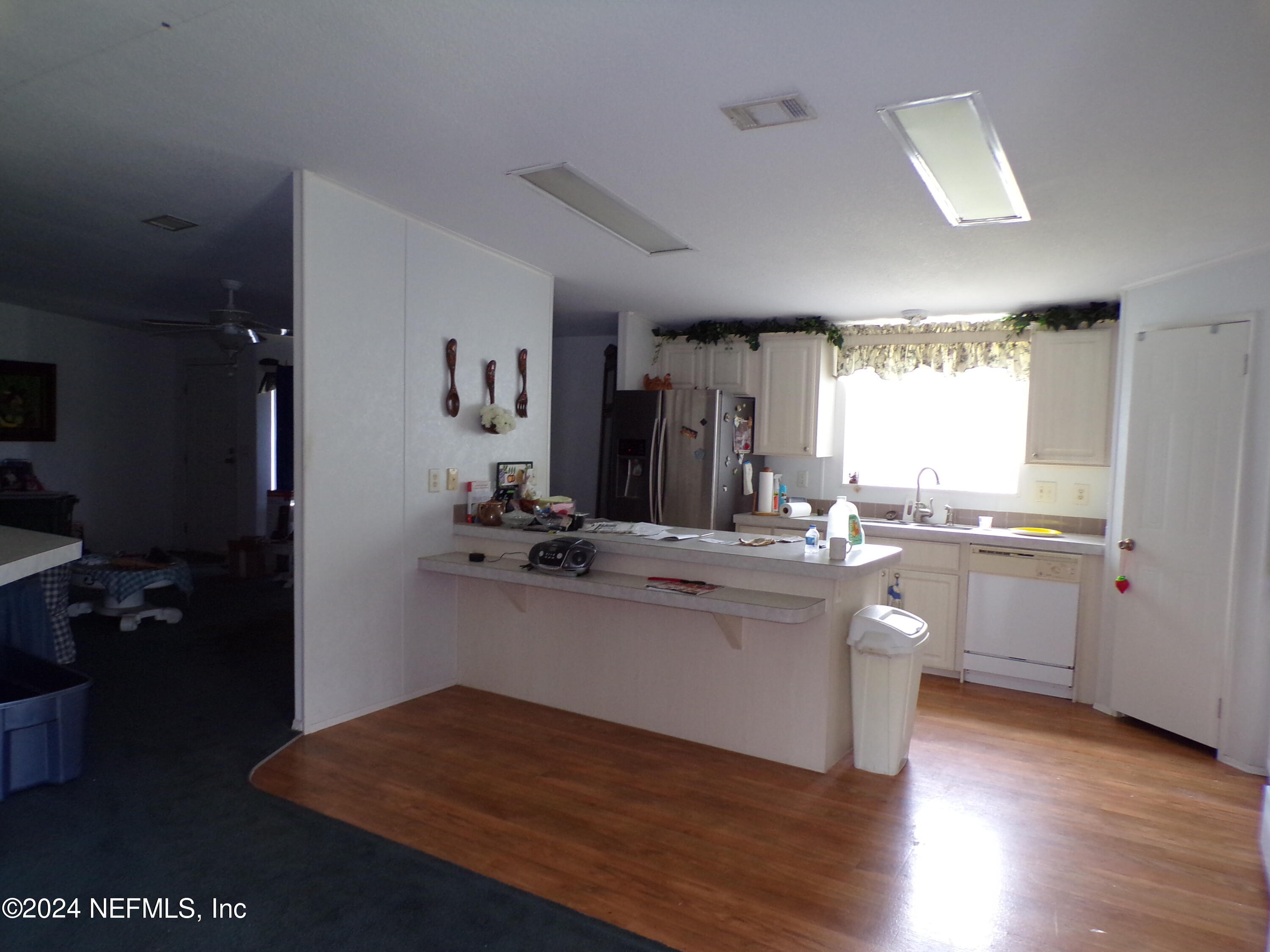 10642 East Bay Road Gibsonton, FL 33534 - Photo 9 of 32 a kitchen with a sink cabinets and wooden floor