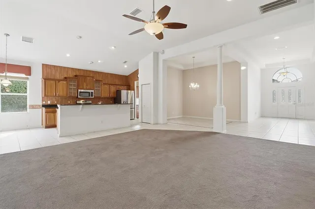 a large kitchen with stainless steel appliances a sink and cabinets