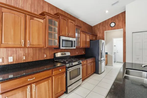 a kitchen with granite countertop a stove top oven cabinetry and granite counter tops
