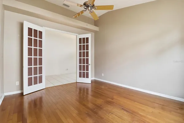 an empty room with closet and a ceiling fan