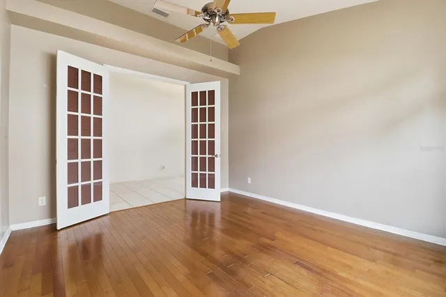 an empty room with closet and a ceiling fan