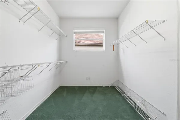 a view of an empty room with a large window and wooden floor