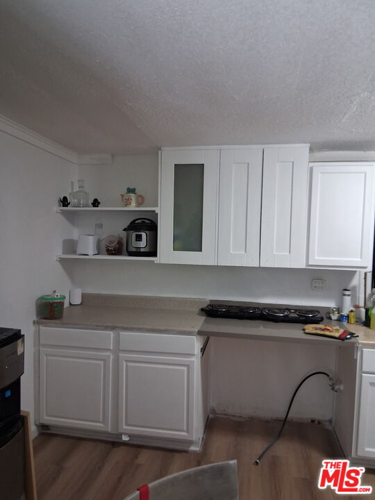 Fort Tejon Road Palmdale, CA 93552 - Photo 14 of 34 a kitchen with white cabinets and black appliances