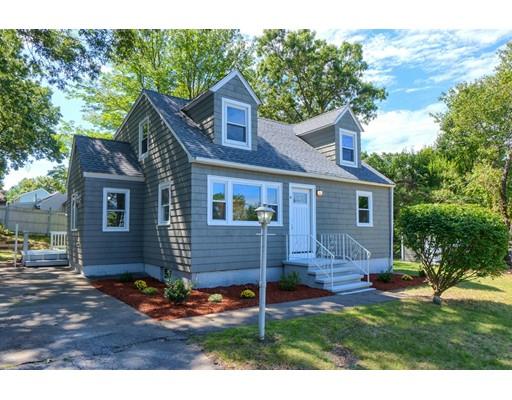 a view of a yard in front of a house with plants and large tree
