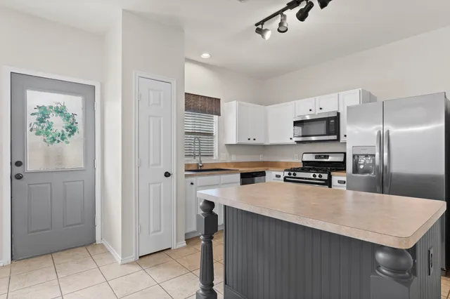 a kitchen with stainless steel appliances a refrigerator sink and microwave