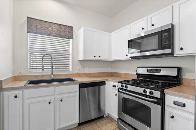 a kitchen with cabinets stainless steel appliances a sink and a microwave