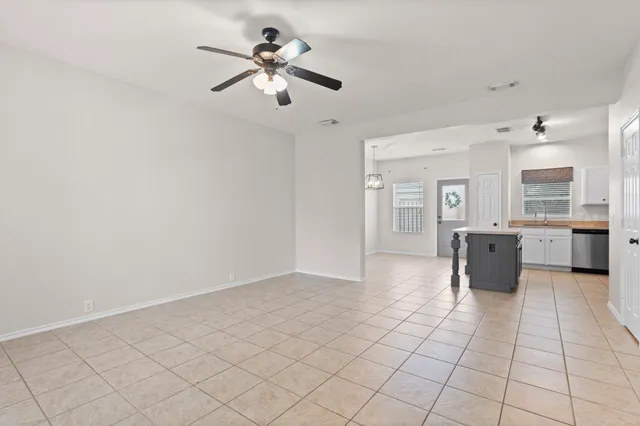 wooden floor with a chandelier fan and kitchen view