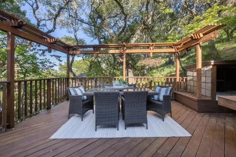 a view of a patio with table and chairs with wooden floor and fence
