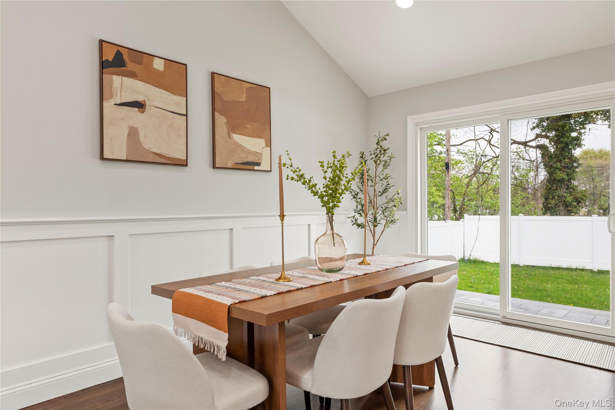 16 Eleanor Road Plainview, NY 11803 - Photo 11 of 28 Dining area featuring wood-finish flooring, wainscoting, and sliders leading to backyard