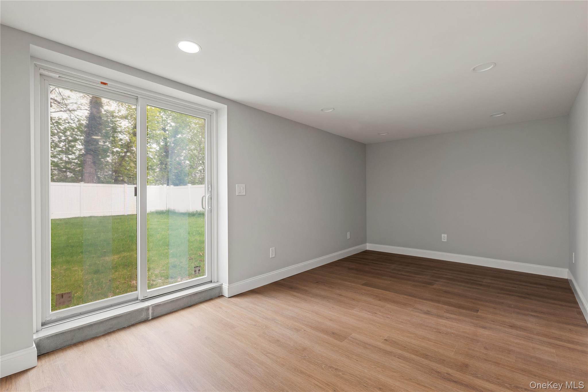 16 Eleanor Road Plainview, NY 11803 - Photo 20 of 28 Spacious family room with wood-finish flooring, recessed lighting, and sliders to backyard
