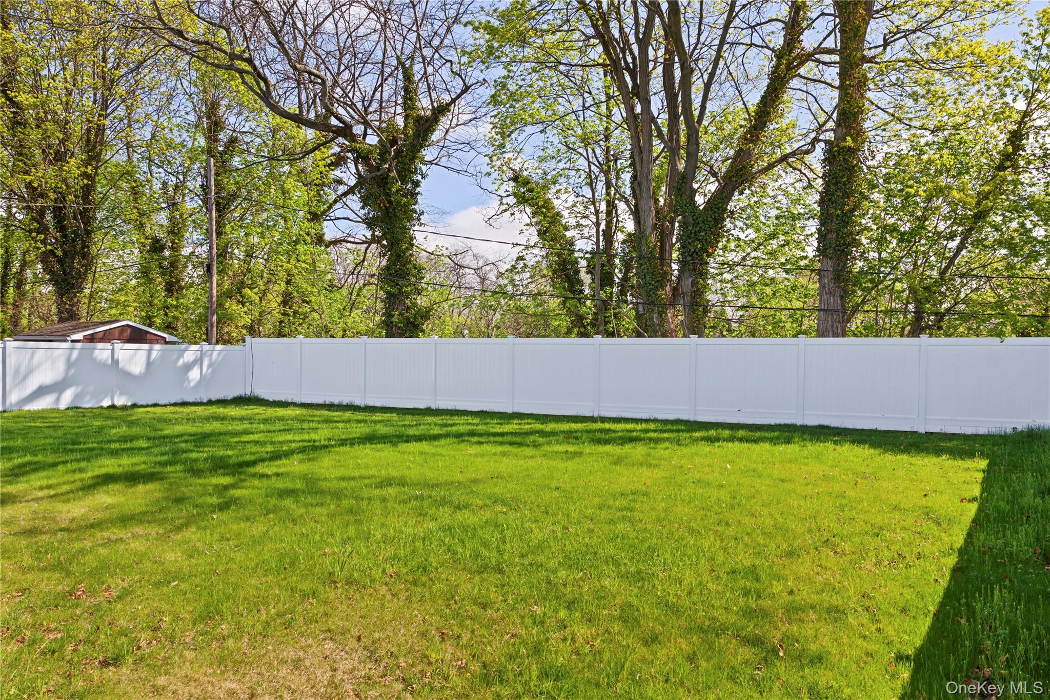 16 Eleanor Road Plainview, NY 11803 - Photo 25 of 28 Expansive backyard featuring a green lawn and a white privacy fence