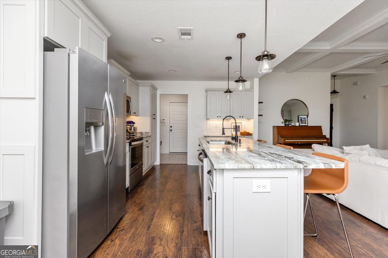 207 Kendall Court Perry, GA 31069 - Photo 20 of 45 a kitchen with stainless steel appliances granite countertop a refrigerator a stove and a sink with wooden floor